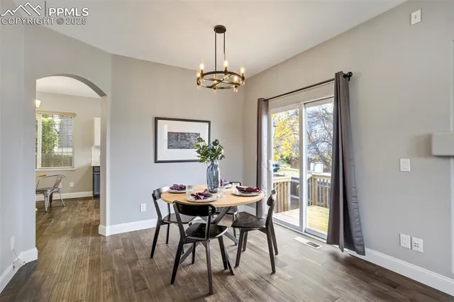 a dining room with furniture a chandelier and wooden floor