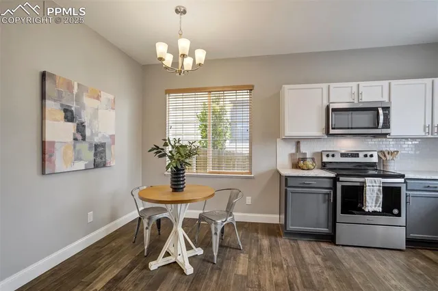 a kitchen with stainless steel appliances a table chairs and a refrigerator