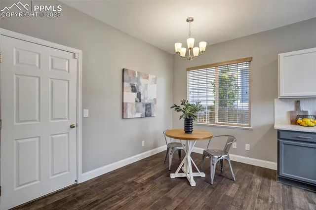 a dining room with furniture a chandelier and wooden floor