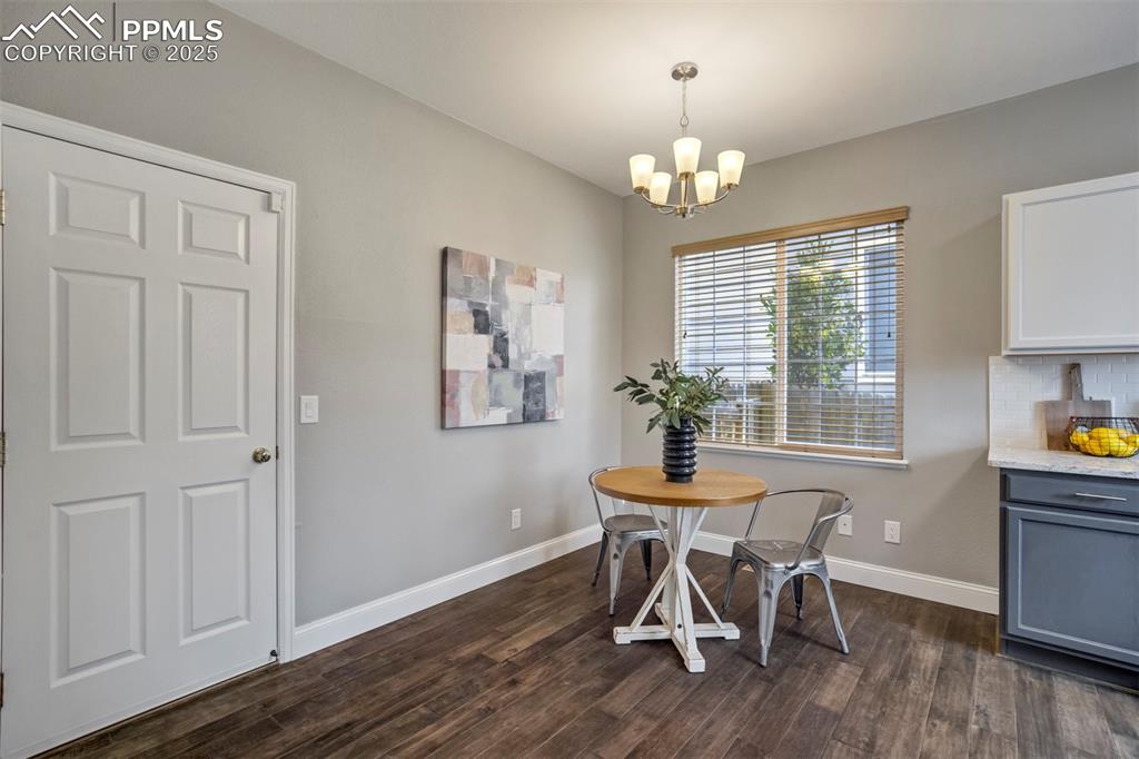 3140 River Valley View Colorado Springs, CO 80922 - Photo 19 of 49 a dining room with furniture a chandelier and wooden floor