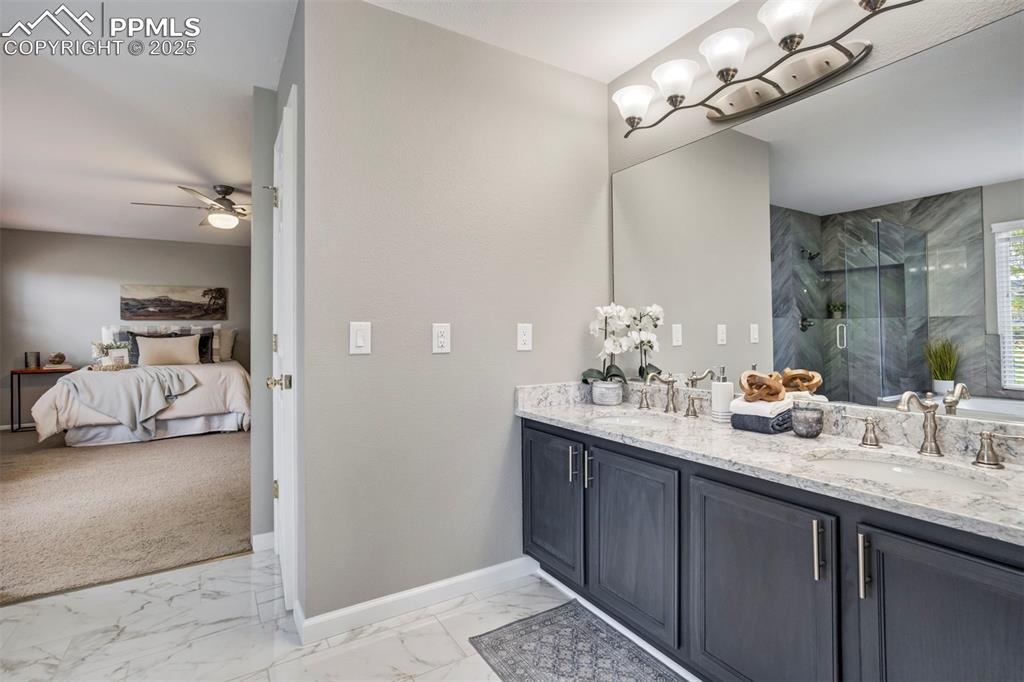 3140 River Valley View Colorado Springs, CO 80922 - Photo 28 of 49 a en suite bathroom with double vanity and a mirror