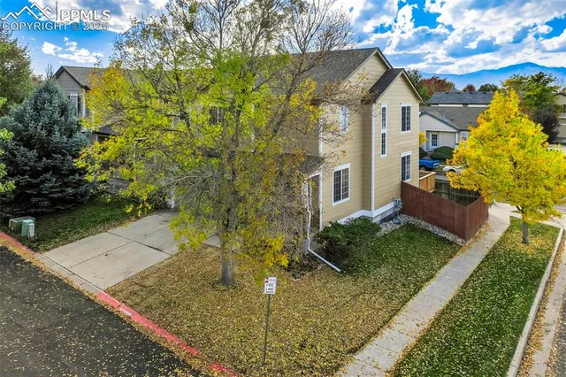 an aerial view of residential houses with outdoor space and parking