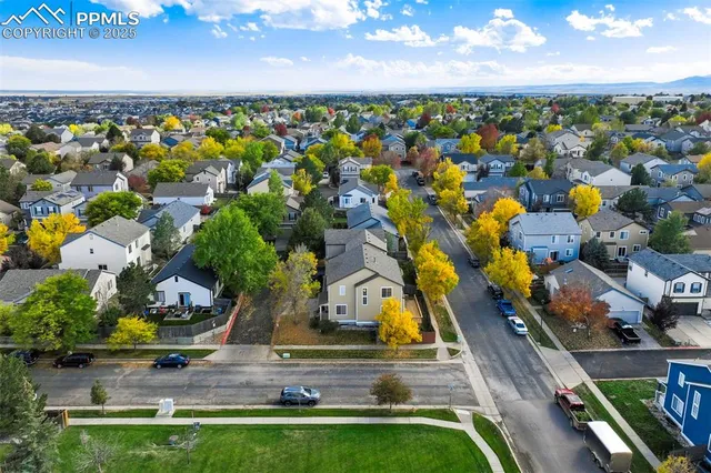 an aerial view of a house with a swimming pool a yard and mountain view in back