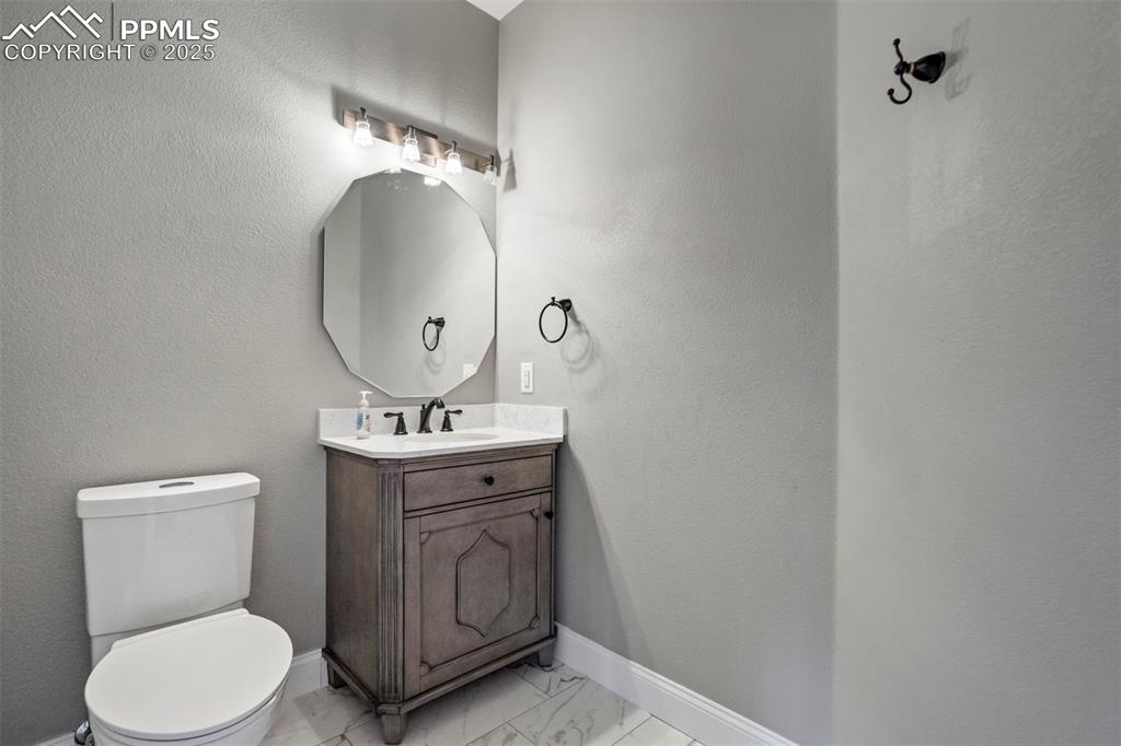3140 River Valley View Colorado Springs, CO 80922 - Photo 7 of 49 a bathroom with a toilet a sink and mirror