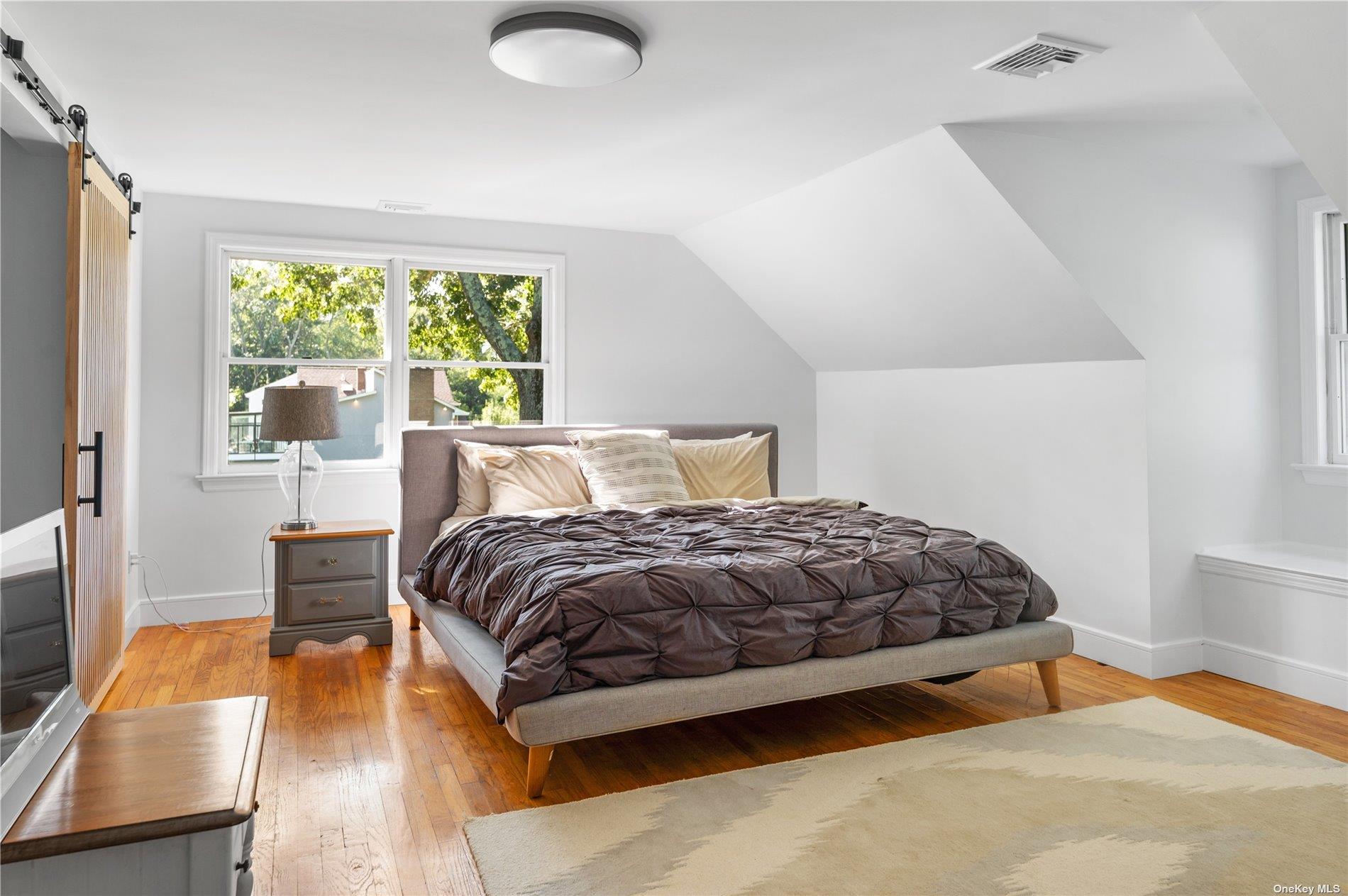 870 Stars Road East Marion, NY 11939 - Photo 13 of 23 a bedroom with a bed and wooden floor