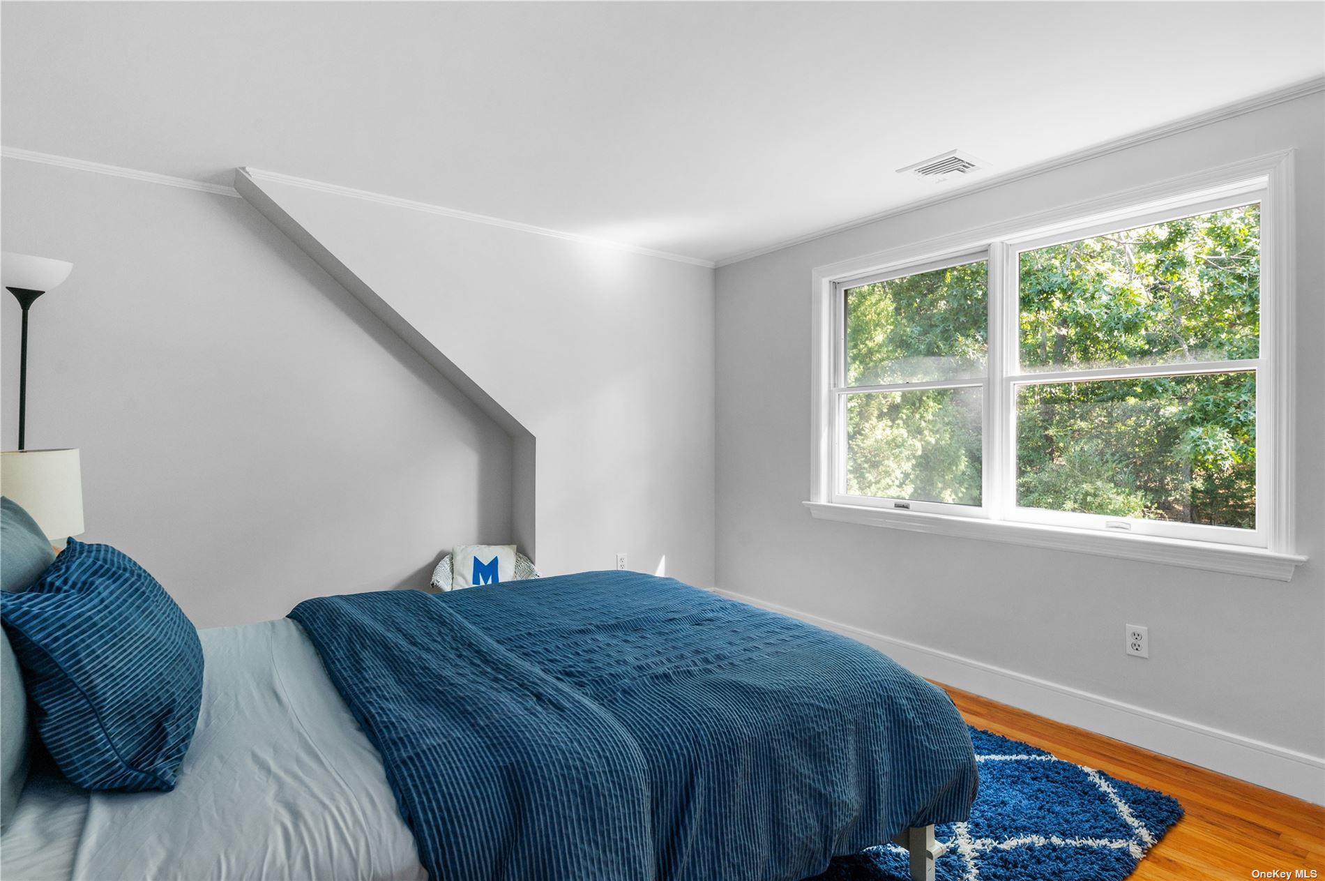 870 Stars Road East Marion, NY 11939 - Photo 16 of 23 a bed sitting in a bedroom next to a window
