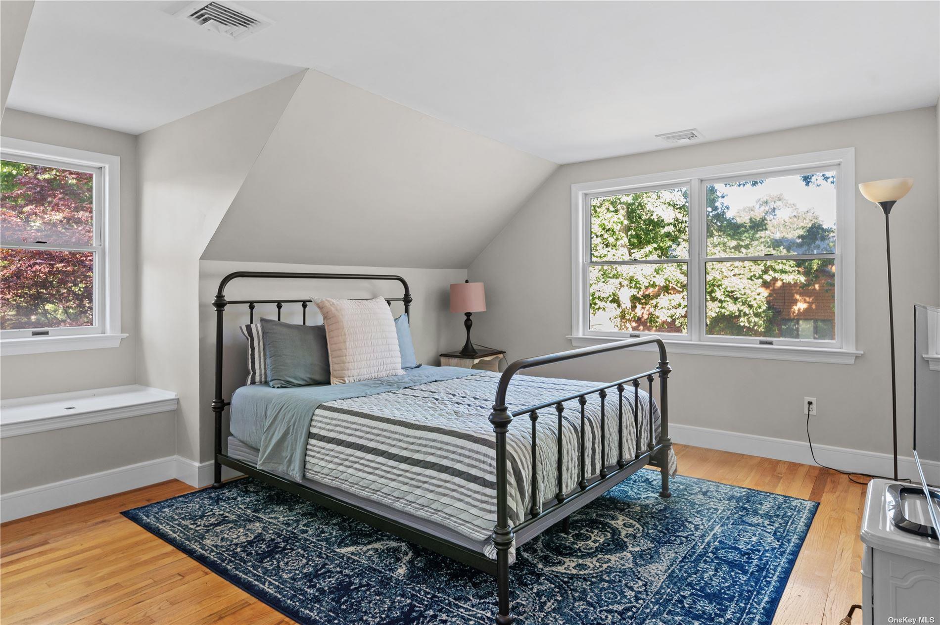 870 Stars Road East Marion, NY 11939 - Photo 18 of 23 a bedroom with a bed and wooden floor