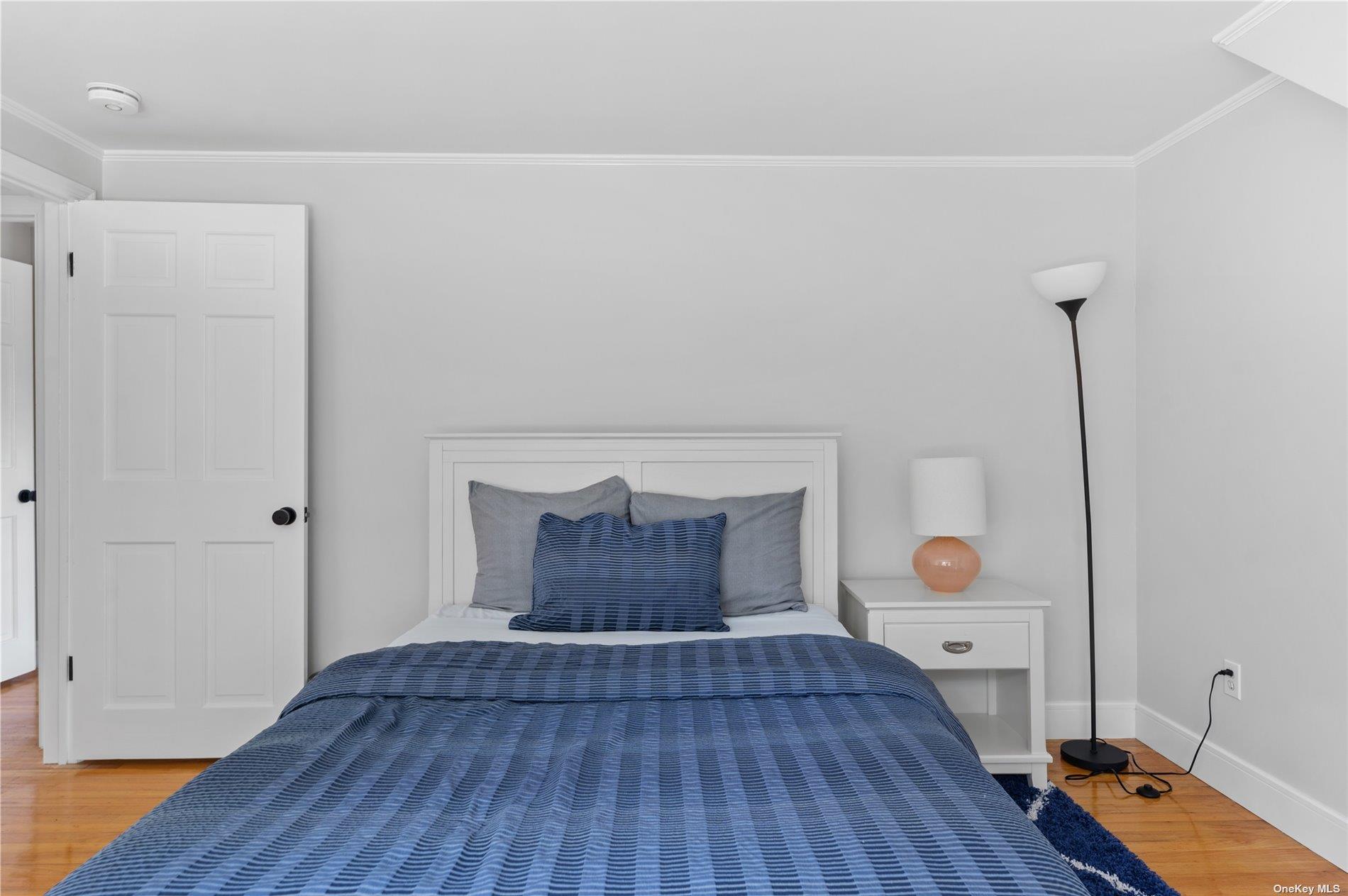 870 Stars Road East Marion, NY 11939 - Photo 20 of 23 a bedroom with a bed and wooden floor