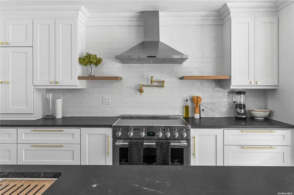 a kitchen with stainless steel appliances granite countertop a stove and a white cabinets