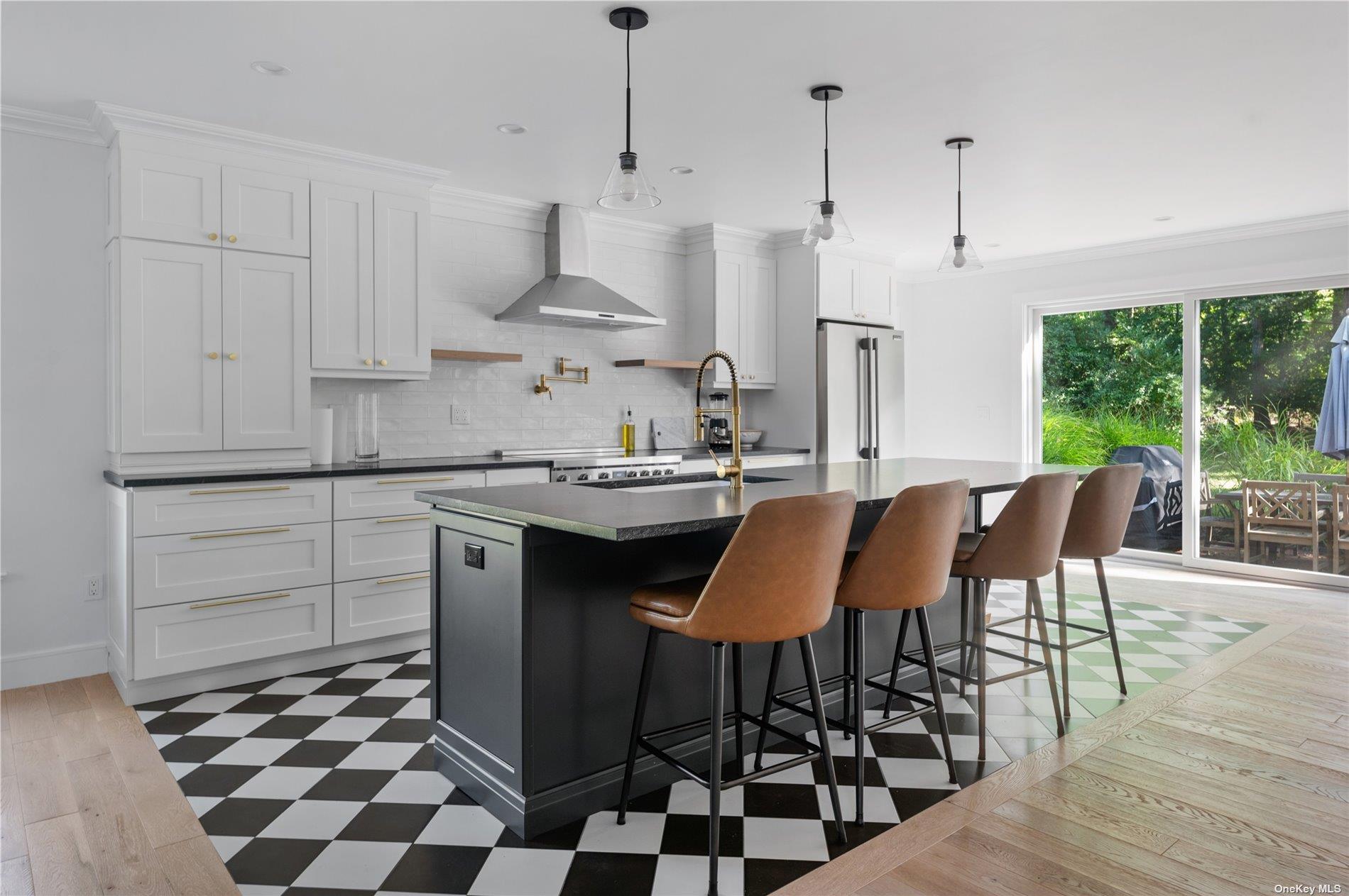 870 Stars Road East Marion, NY 11939 - Photo 6 of 23 a kitchen with stainless steel appliances kitchen island granite countertop a sink a stove a refrigerator and white cabinets with wooden floor