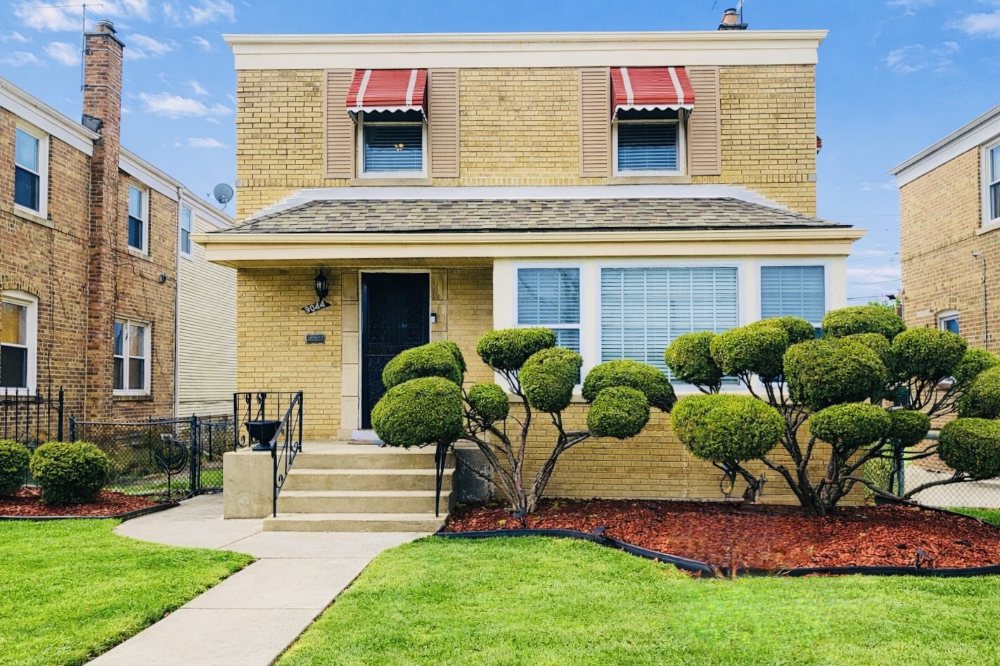 9044 South Merrill Avenue Chicago, IL 60617 - Photo 1 of 46 a front view of a house with garden
