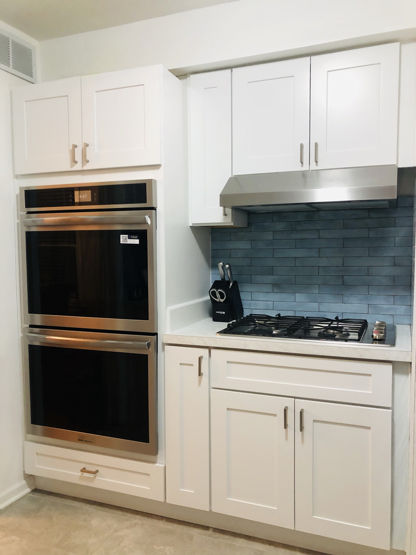 9044 South Merrill Avenue Chicago, IL 60617 - Photo 5 of 46 a kitchen with white cabinets and white appliances