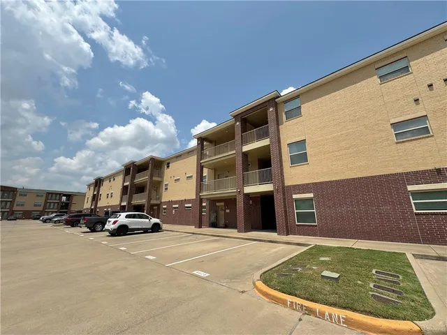 an empty room with wooden floor ceiling fan and windows