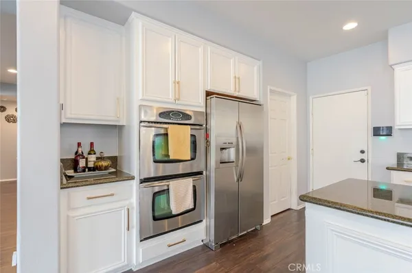 a kitchen with stainless steel appliances granite countertop a refrigerator and a stove top oven