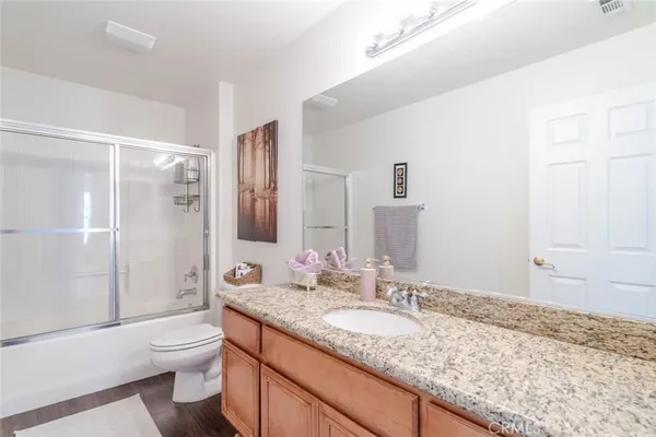 a bathroom with a granite countertop sink toilet and shower