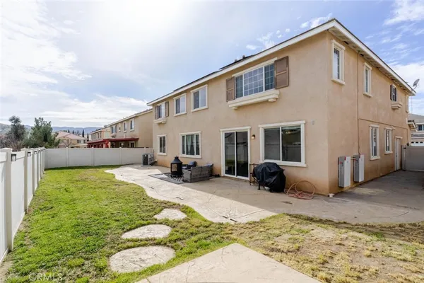 a view of a house with backyard and sitting area