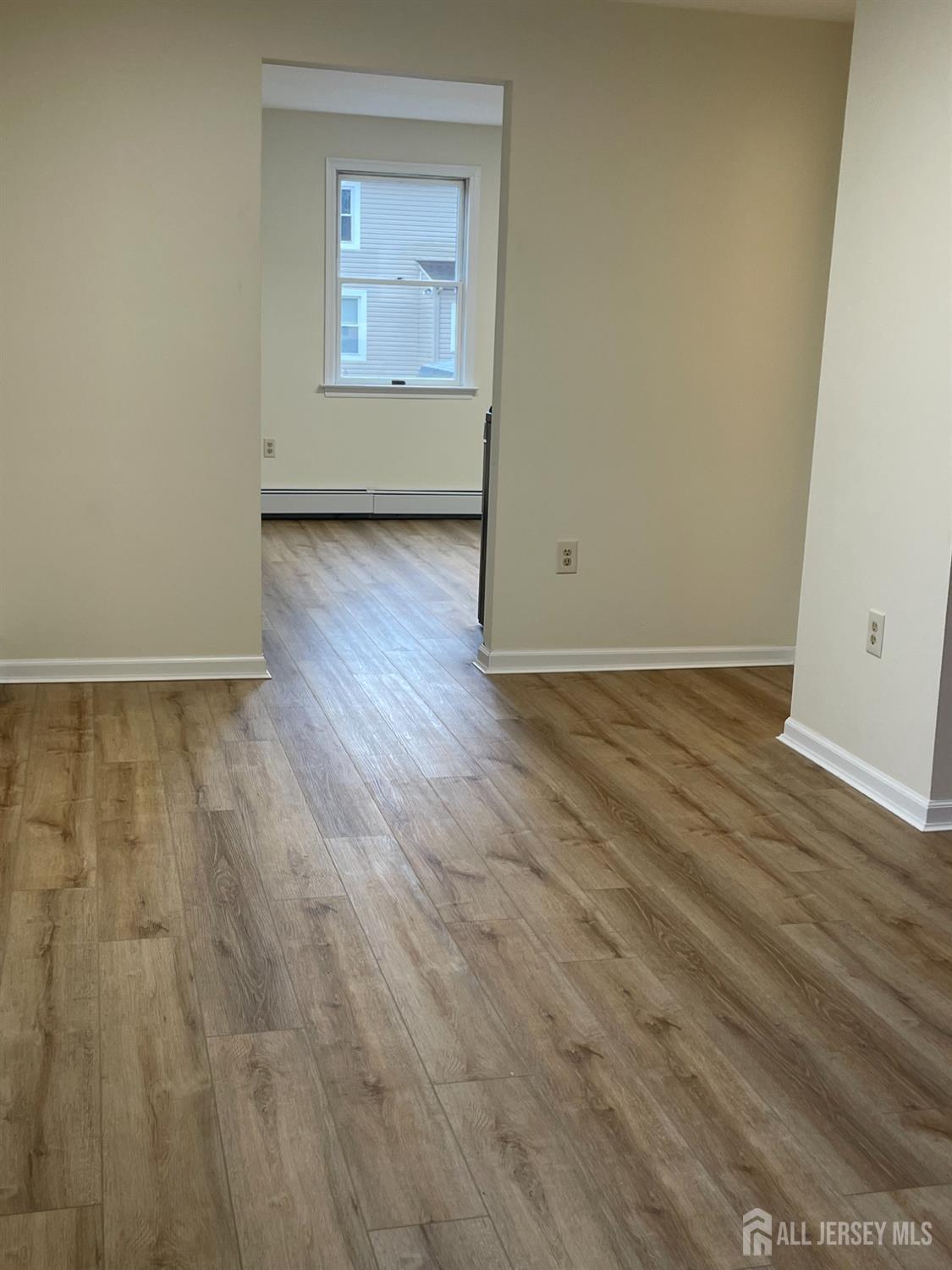 351 John Street, Unit 2 South Amboy, NJ 08879 - Photo 2 of 12 an empty room with wooden floor and windows