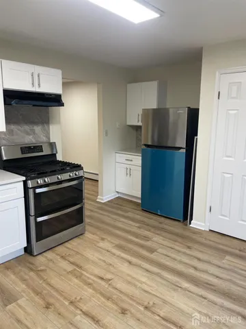 a kitchen with a refrigerator and a stove top oven