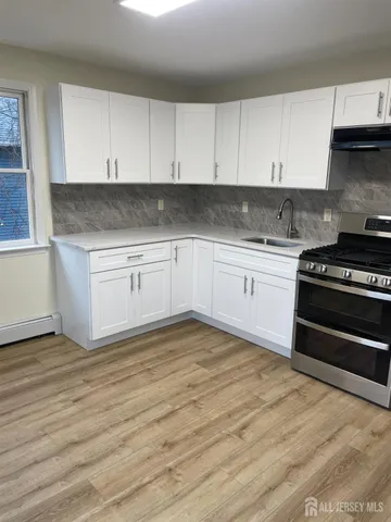 a kitchen with granite countertop a stove and cabinets