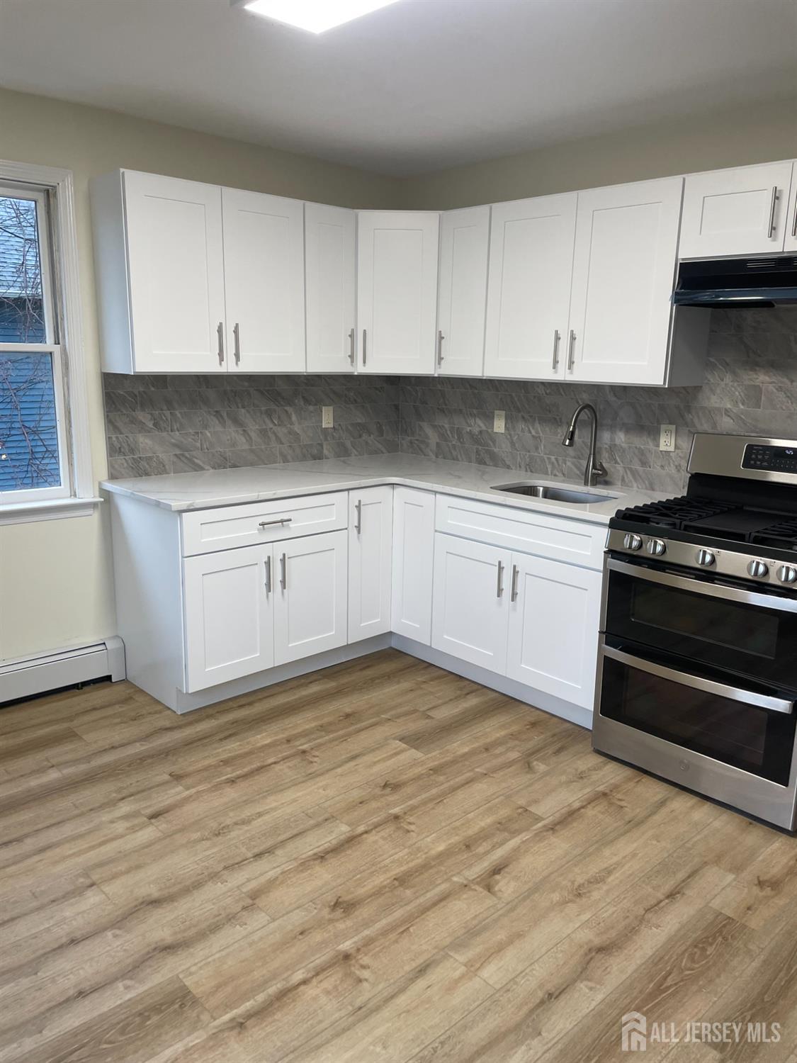 351 John Street, Unit 2 South Amboy, NJ 08879 - Photo 6 of 12 a kitchen with granite countertop a stove and cabinets