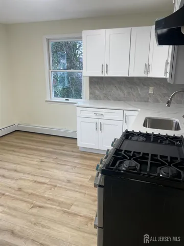 a kitchen with a stove a window and cabinets