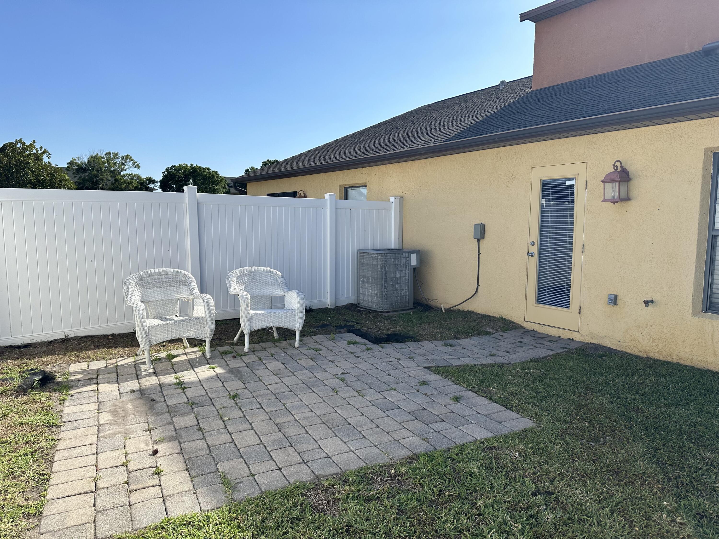 910 Luminary Circle, Unit 103 Melbourne, FL 32901 - Photo 25 of 31 a backyard of a house with table and chairs