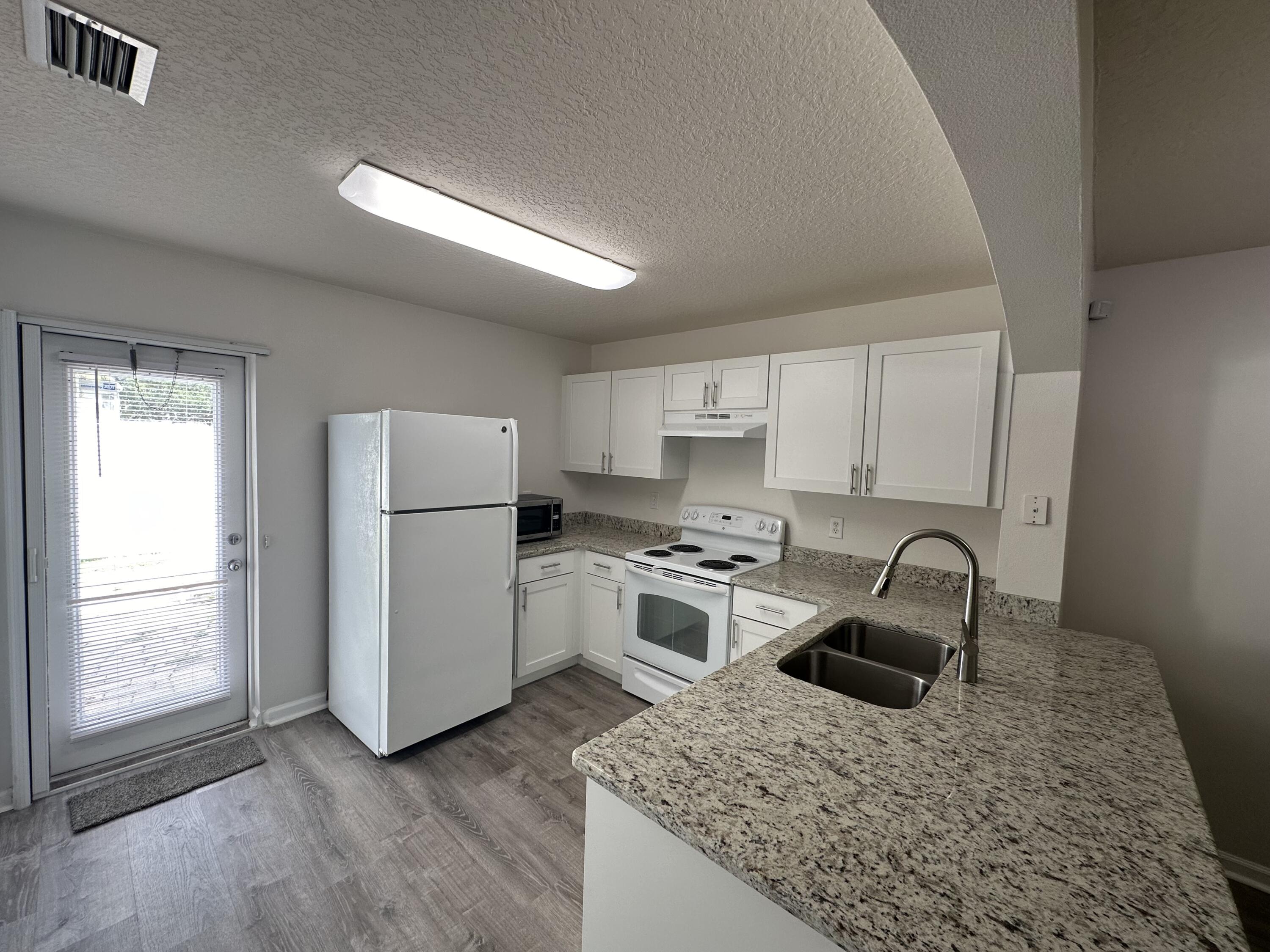 910 Luminary Circle, Unit 103 Melbourne, FL 32901 - Photo 7 of 31 a kitchen with a stove sink and refrigerator