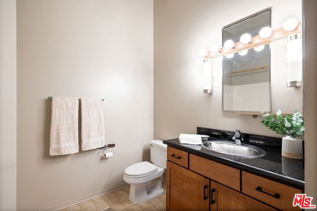 a bathroom with a sink a toilet and a large mirror