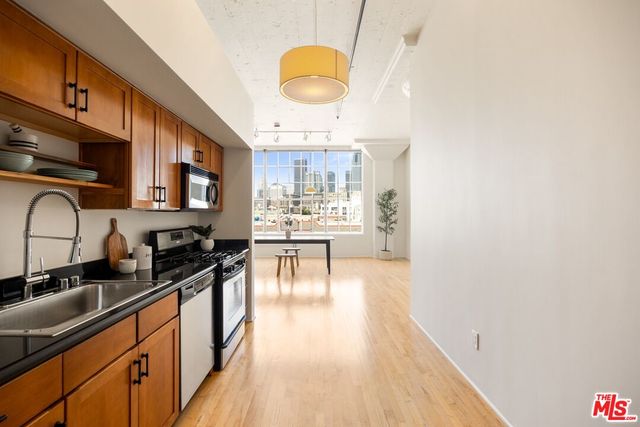 a kitchen with stainless steel appliances granite countertop a sink stove and cabinets