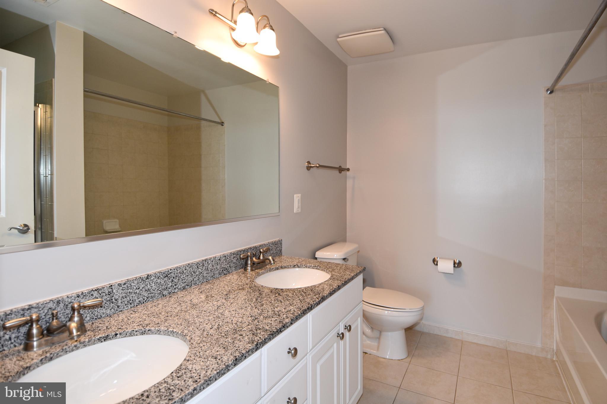 3650 South Glebe Road, Unit 662 Arlington, VA 22202 - Photo 21 of 63 a bathroom with a granite countertop sink toilet a large mirror and shower