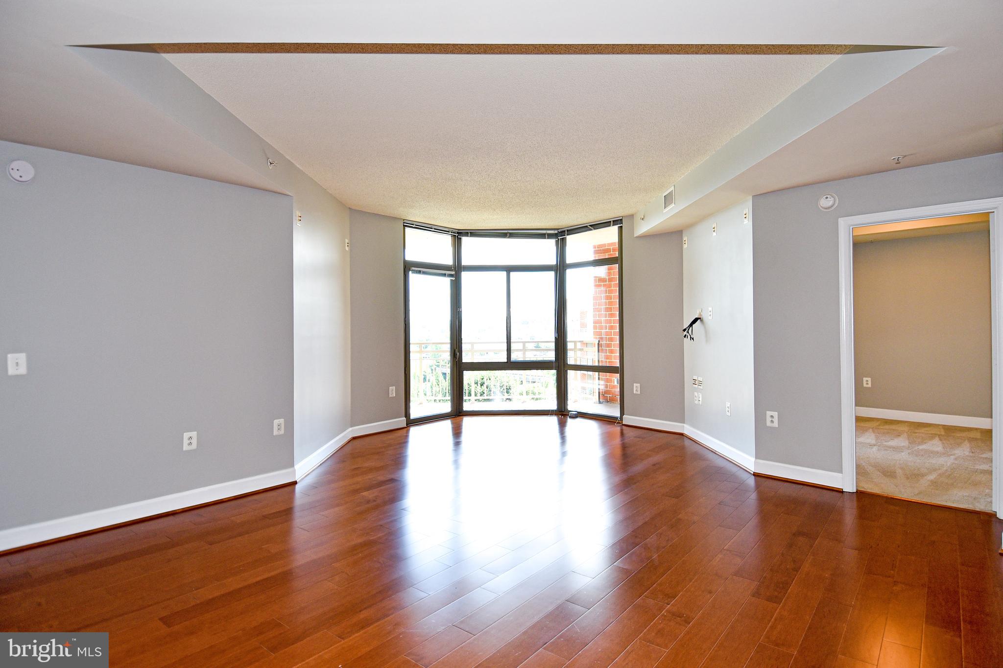 3650 South Glebe Road, Unit 662 Arlington, VA 22202 - Photo 7 of 63 a view of an empty room with wooden floor and a window