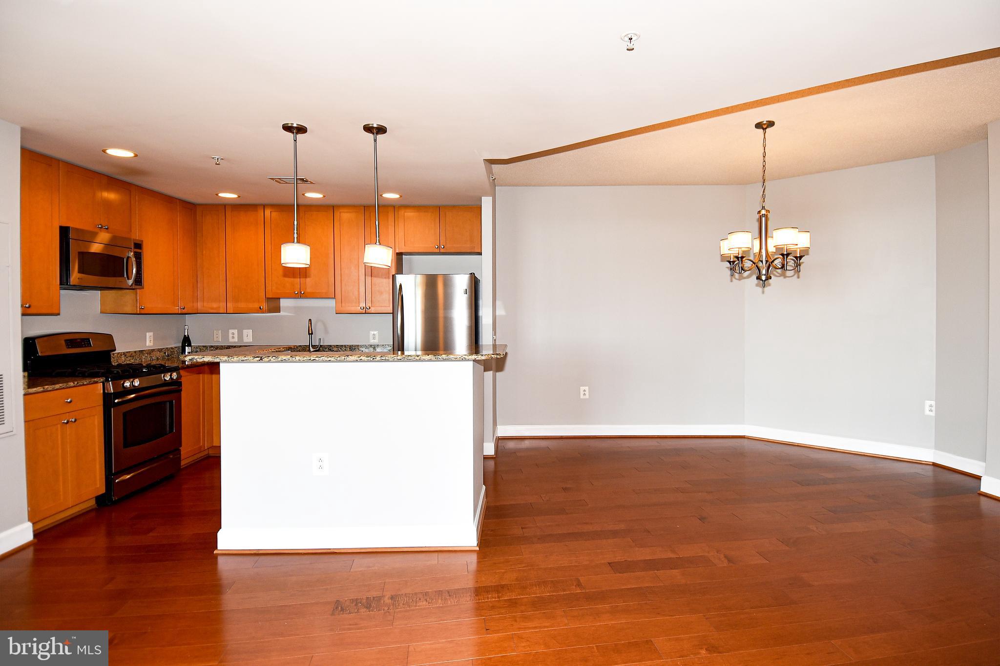 3650 South Glebe Road, Unit 662 Arlington, VA 22202 - Photo 8 of 63 a view of a kitchen with kitchen island a sink wooden floor and a refrigerator
