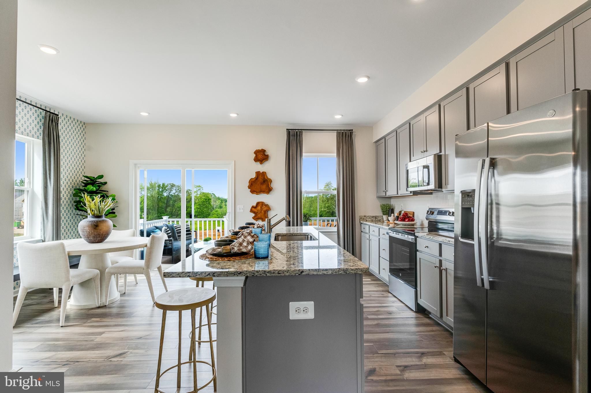 335 Sandy Btm Circle Ranson, WV 25438 - Photo 3 of 20 a kitchen with stainless steel appliances granite countertop a refrigerator a stove and a dining table with wooden floor