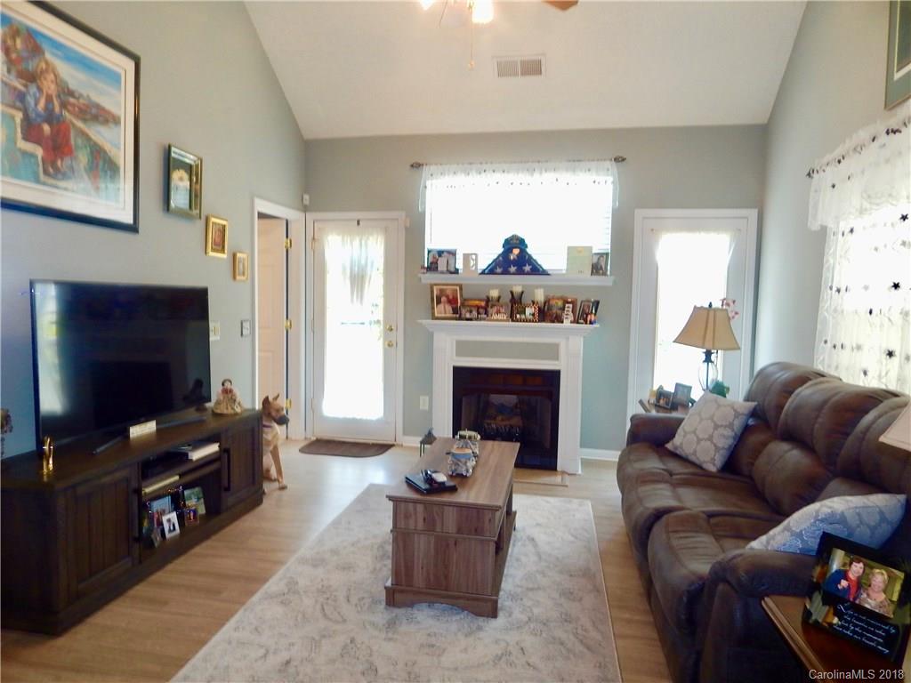 16720 Timber Crossing Road Charlotte, NC 28213 - Photo 14 of 33 a living room with furniture a flat screen tv and a fireplace