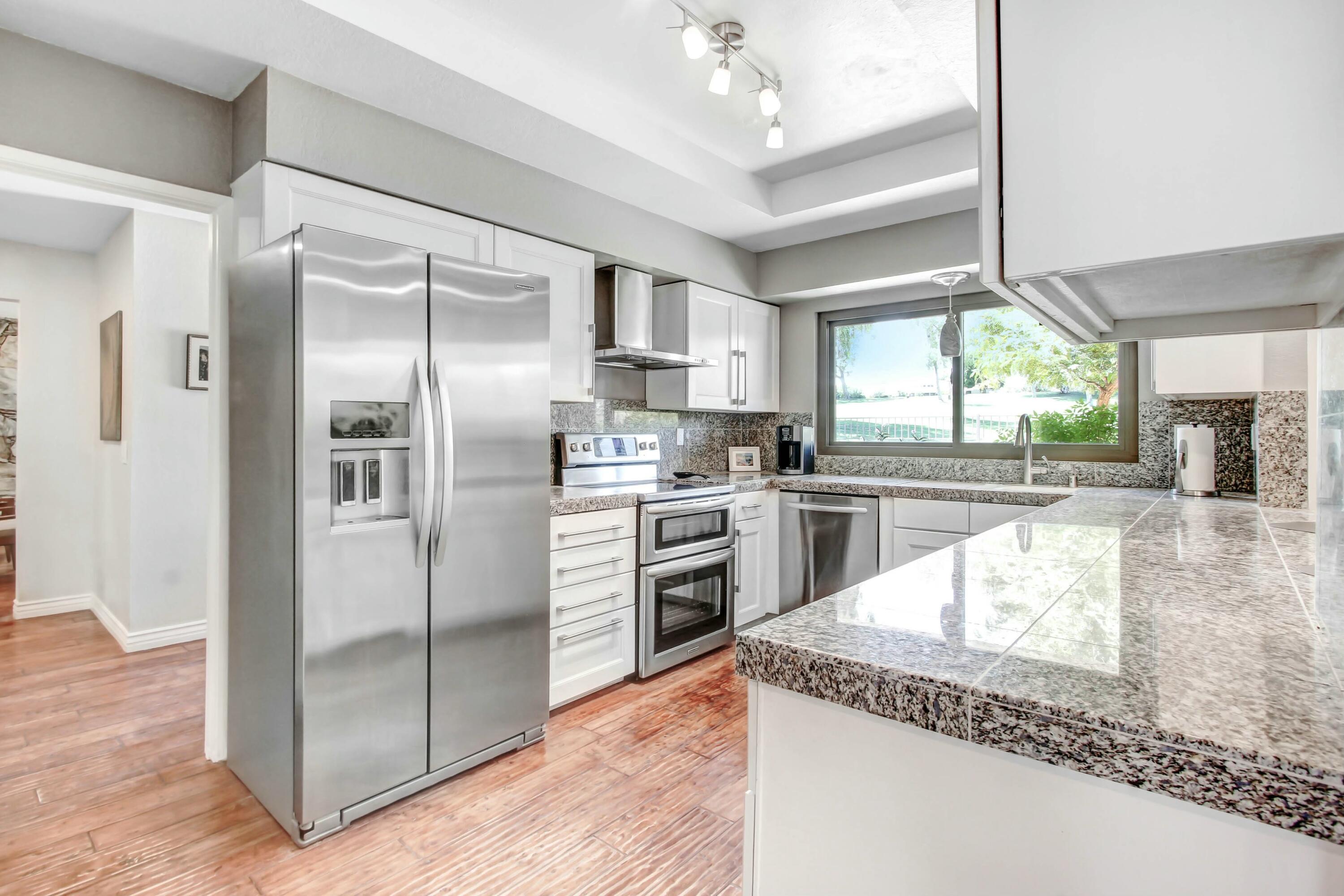 43480 Port Maria Road Bermuda Dunes, CA 92203 - Photo 10 of 24 a kitchen with stainless steel appliances granite countertop a refrigerator a stove and a sink