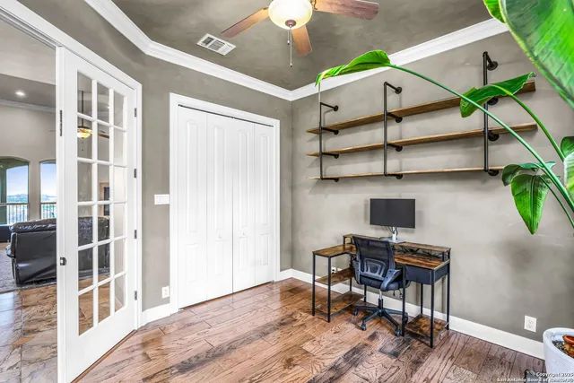 a view of a workspace with furniture and a window