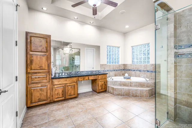 a bathroom with a granite countertop sink a toilet a mirror and shower