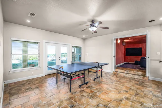 a media room with lots of chairs and chandelier