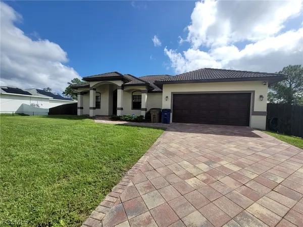 a front view of a house with a yard and garage