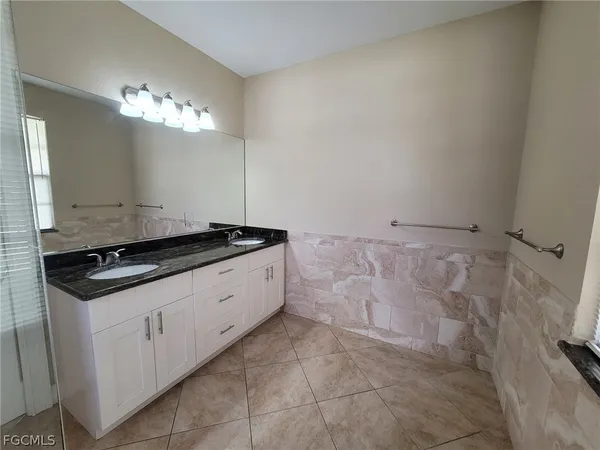 a bathroom with a granite countertop sink a toilet and a mirror