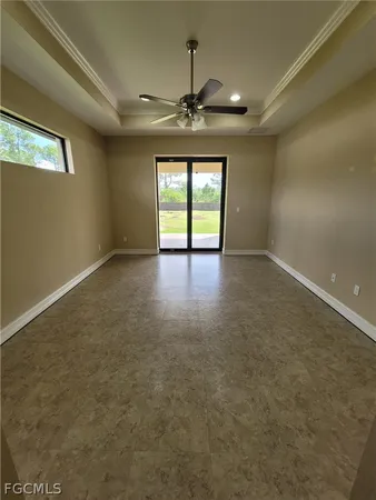 an empty room with windows and ceiling fan