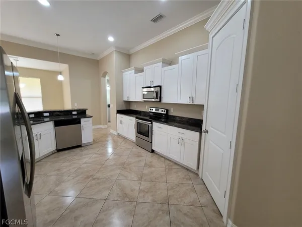 a kitchen with granite countertop a stove sink and cabinets
