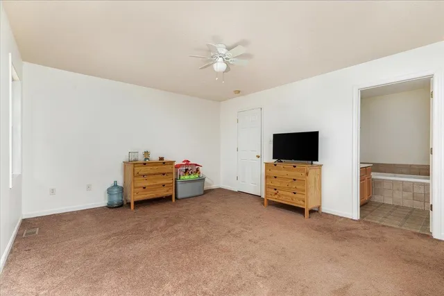 a spacious bedroom with a bed and a chandelier