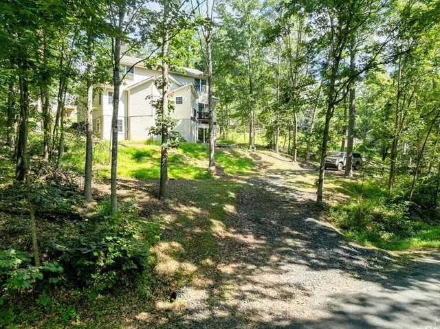 a view of a swimming pool with lawn chairs and a big yard