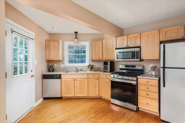 a kitchen with stainless steel appliances granite countertop a refrigerator stove and microwave