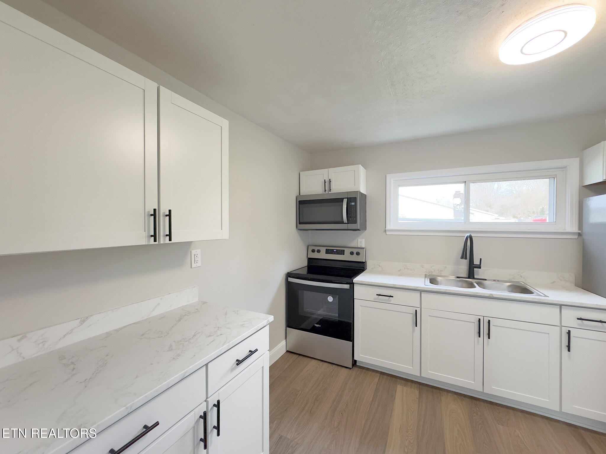 150 Connor Street Jacksboro, TN 37757 - Photo 7 of 22 a kitchen with a sink stove and microwave