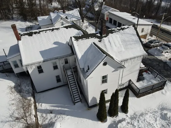 a view of a white house with wooden fence