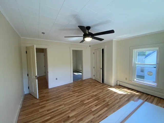 a view of a livingroom with wooden floor and a ceiling fan