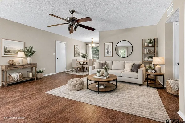 an empty room with wooden floor chandelier fan and windows