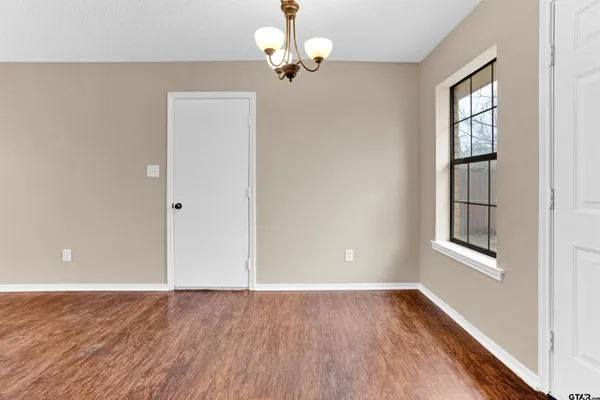 an empty room with windows and cabinet